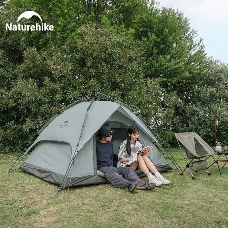 Magazaw automatic camping tent set up in a garden with two people relaxing and reading