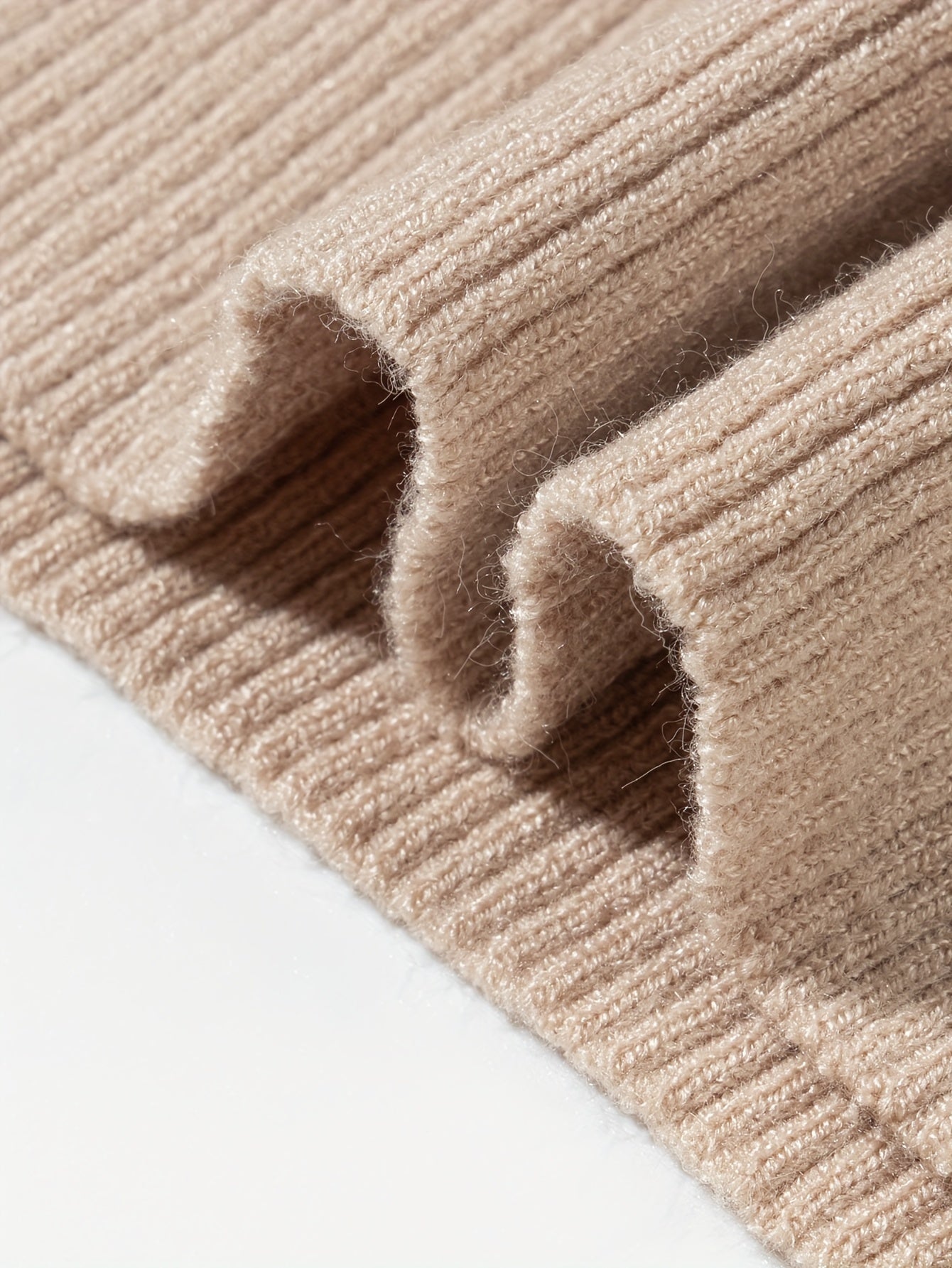 Close-up of soft beige fabric showcasing the texture of a slim fit turtleneck tee