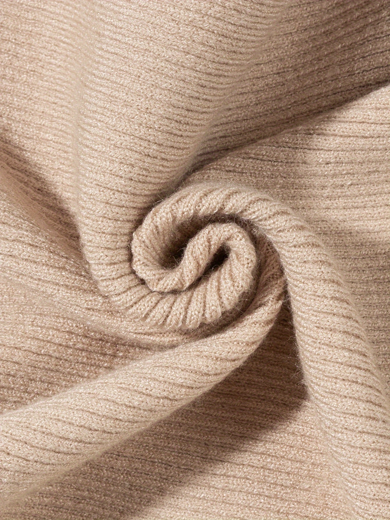 Soft beige fabric of a slim fit turtleneck tee with a ribbed texture, perfect for layering