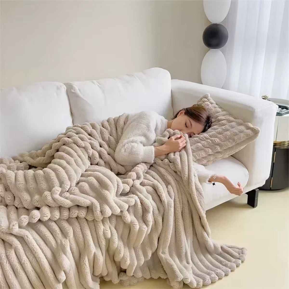 Cozy woman resting on a sofa wrapped in a soft plush velvet blanket for warmth and comfort